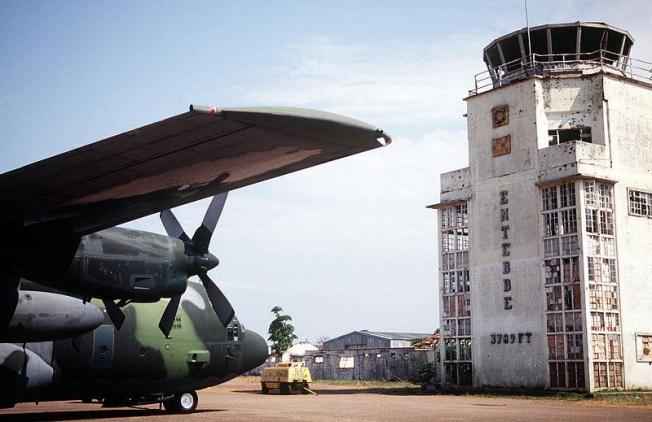 A C-130 Hercules in front of old terminal of Entebbe Airport, after arriving with food and supplies for the Rwandan refugee camps in 1994. Bullet hole damage from the 1976 raid is still visible.
